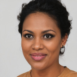 Joyful black young-adult female with long  brown hair and brown eyes