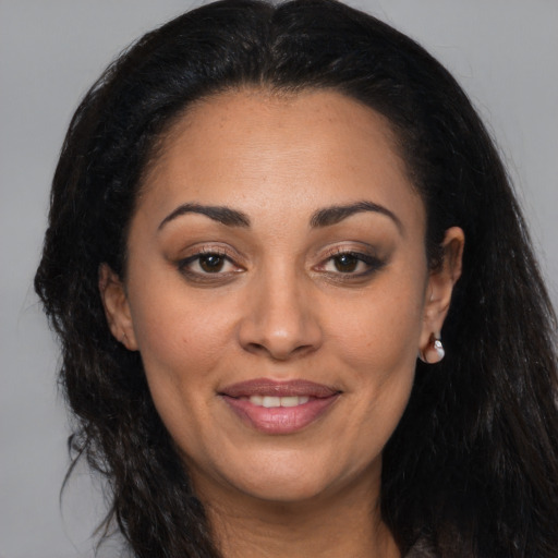 Joyful latino adult female with long  brown hair and brown eyes