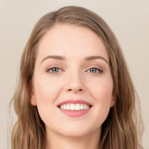 Joyful white young-adult female with long  brown hair and blue eyes