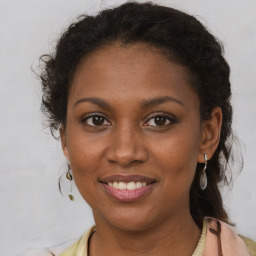 Joyful black young-adult female with long  brown hair and brown eyes