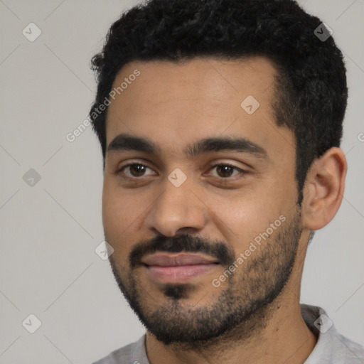 Joyful latino young-adult male with short  black hair and brown eyes