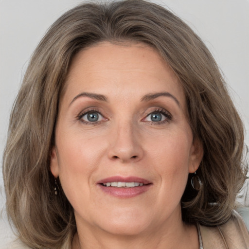 Joyful white adult female with medium  brown hair and grey eyes