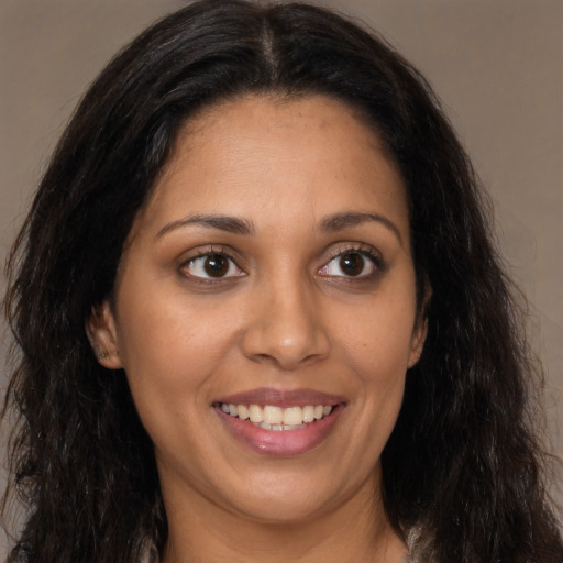 Joyful latino young-adult female with long  brown hair and brown eyes