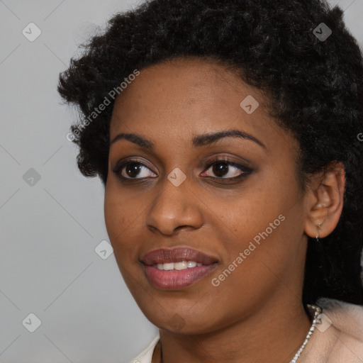 Joyful black young-adult female with short  black hair and brown eyes