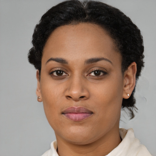 Joyful black young-adult female with short  brown hair and brown eyes