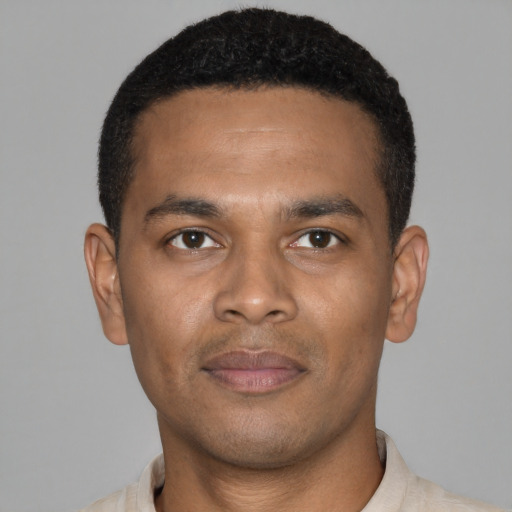 Joyful black young-adult male with short  black hair and brown eyes