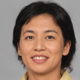 Joyful asian adult female with medium  brown hair and brown eyes