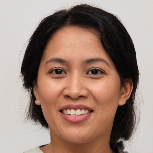 Joyful asian adult female with medium  brown hair and brown eyes