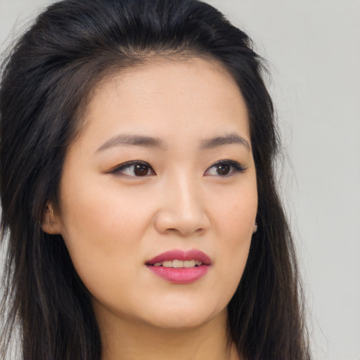 Joyful asian young-adult female with long  brown hair and brown eyes