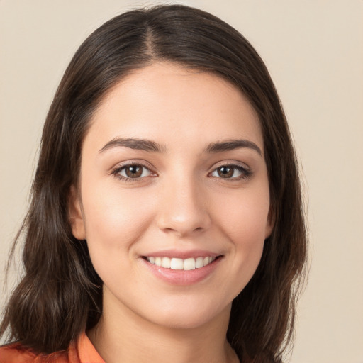 Joyful white young-adult female with long  brown hair and brown eyes