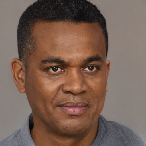Joyful black adult male with short  black hair and brown eyes