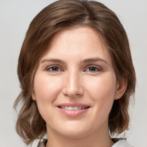 Joyful white young-adult female with medium  brown hair and grey eyes