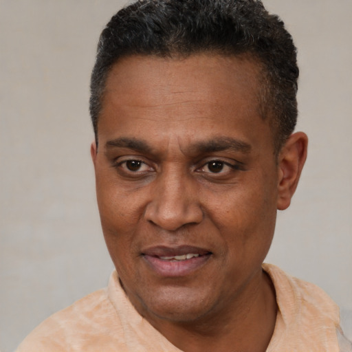 Joyful black adult male with short  black hair and brown eyes