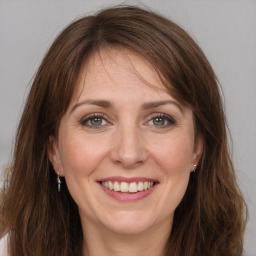 Joyful white adult female with long  brown hair and grey eyes