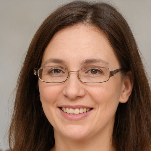 Joyful white adult female with long  brown hair and grey eyes