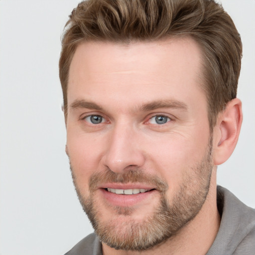 Joyful white adult male with short  brown hair and grey eyes