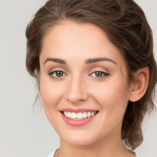 Joyful white young-adult female with medium  brown hair and green eyes