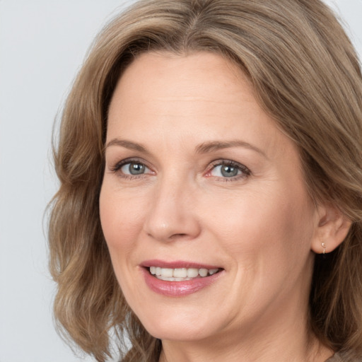 Joyful white adult female with medium  brown hair and blue eyes