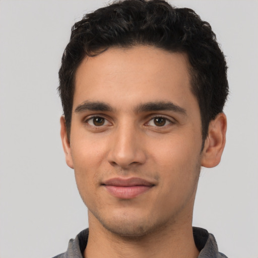 Joyful latino young-adult male with short  brown hair and brown eyes