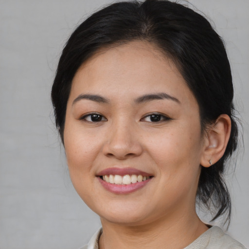 Joyful asian young-adult female with medium  brown hair and brown eyes