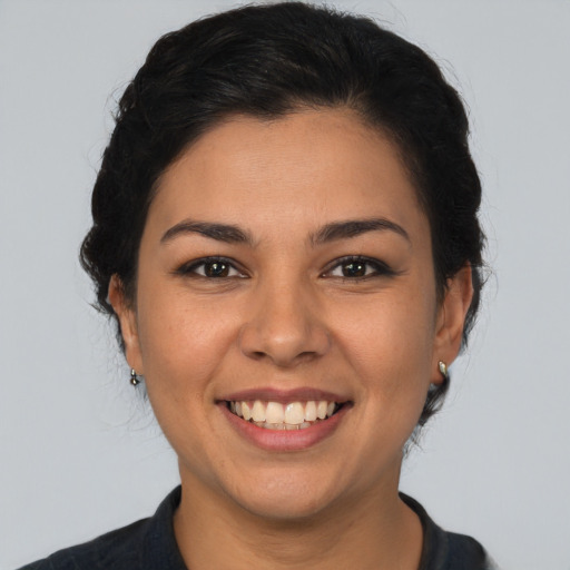 Joyful latino young-adult female with short  brown hair and brown eyes