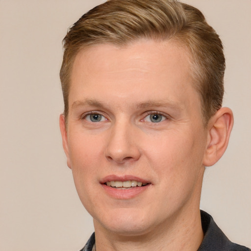 Joyful white adult male with short  brown hair and blue eyes