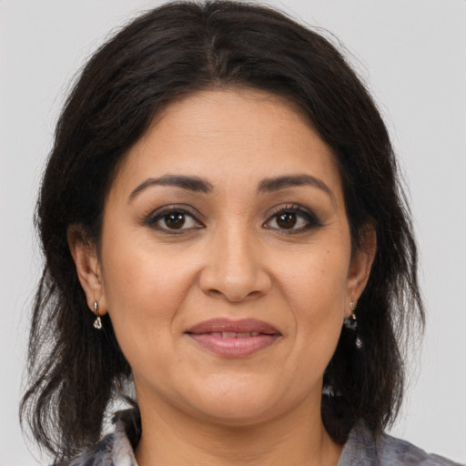 Joyful latino adult female with medium  brown hair and brown eyes