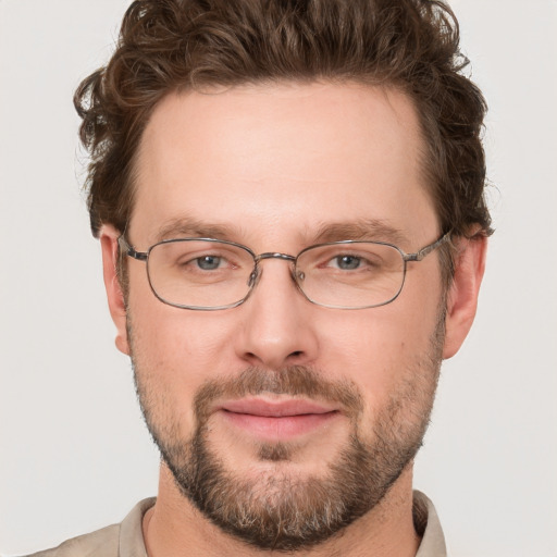 Joyful white young-adult male with short  brown hair and green eyes