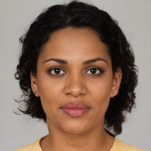 Joyful black adult female with medium  brown hair and brown eyes