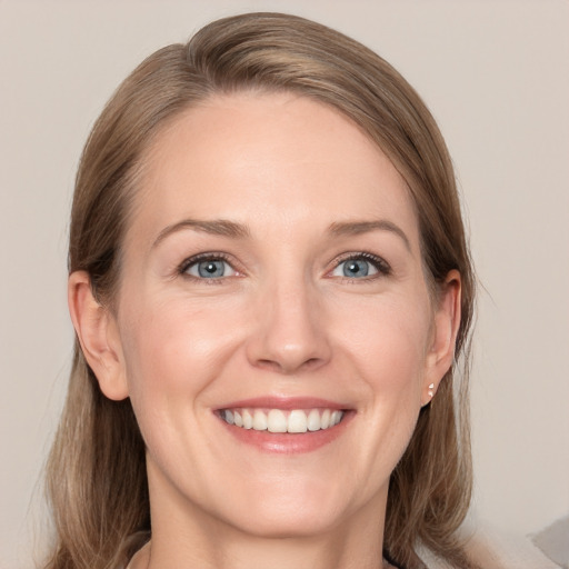 Joyful white adult female with medium  brown hair and grey eyes