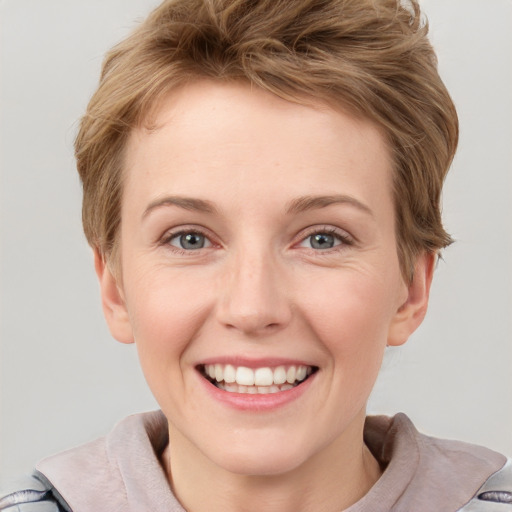 Joyful white young-adult female with short  brown hair and grey eyes