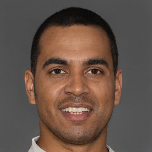 Joyful black young-adult male with short  brown hair and brown eyes