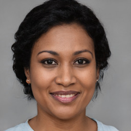 Joyful black adult female with medium  brown hair and brown eyes