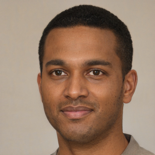 Joyful black young-adult male with short  black hair and brown eyes