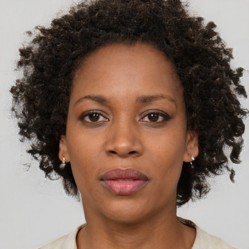 Joyful black adult female with medium  brown hair and brown eyes