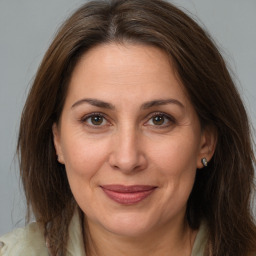 Joyful white adult female with long  brown hair and brown eyes