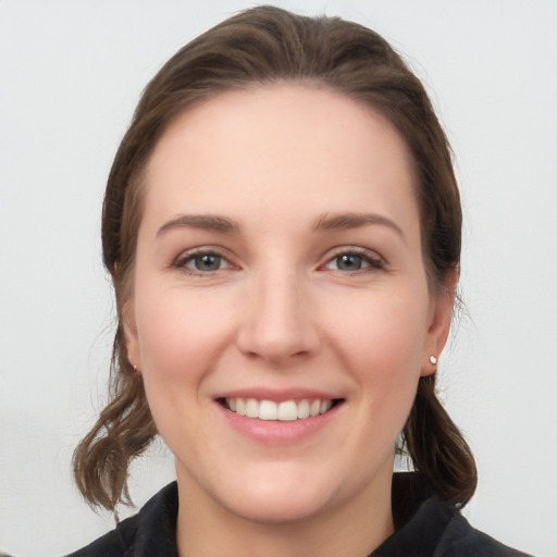 Joyful white young-adult female with medium  brown hair and grey eyes