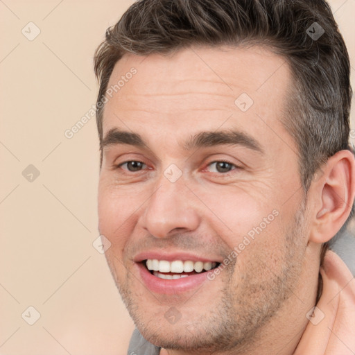 Joyful white adult male with short  brown hair and brown eyes