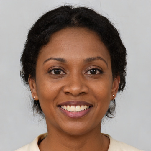 Joyful black adult female with medium  brown hair and brown eyes