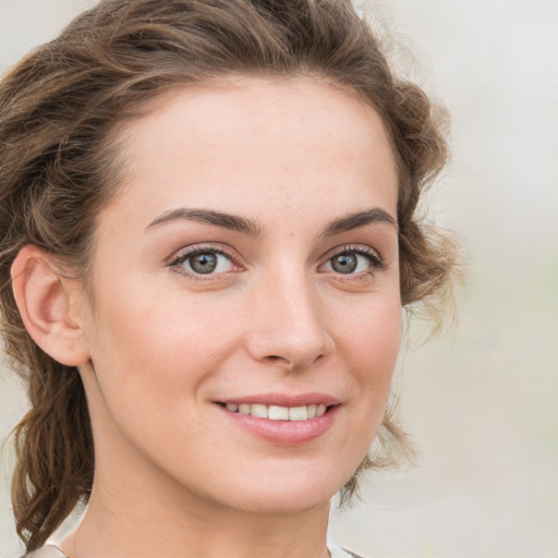 Joyful white young-adult female with medium  brown hair and green eyes