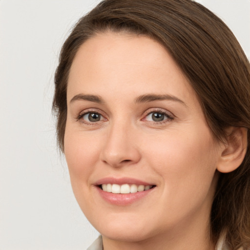 Joyful white young-adult female with medium  brown hair and grey eyes