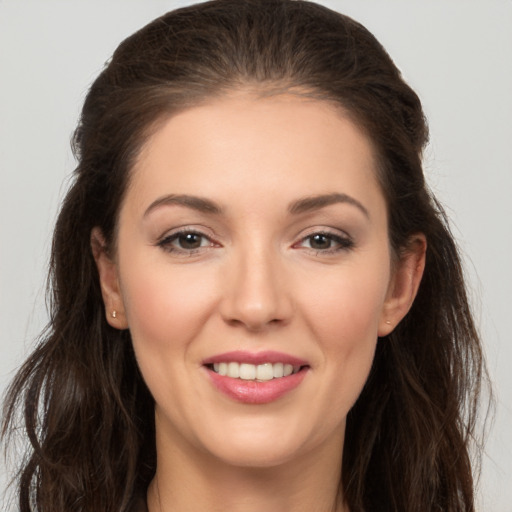 Joyful white young-adult female with long  brown hair and brown eyes