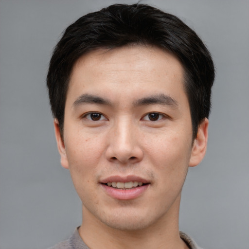 Joyful asian young-adult male with short  brown hair and brown eyes