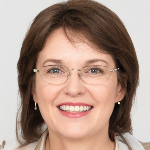 Joyful white adult female with medium  brown hair and grey eyes