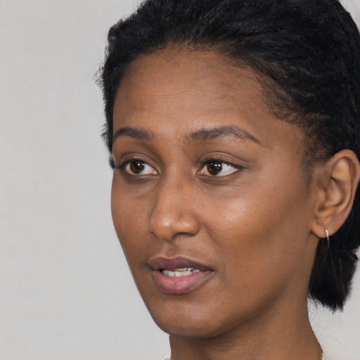Joyful black young-adult female with short  brown hair and brown eyes