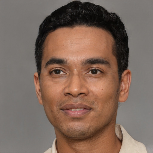 Joyful latino young-adult male with short  black hair and brown eyes