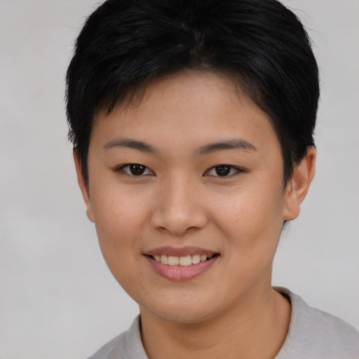Joyful asian young-adult female with short  brown hair and brown eyes