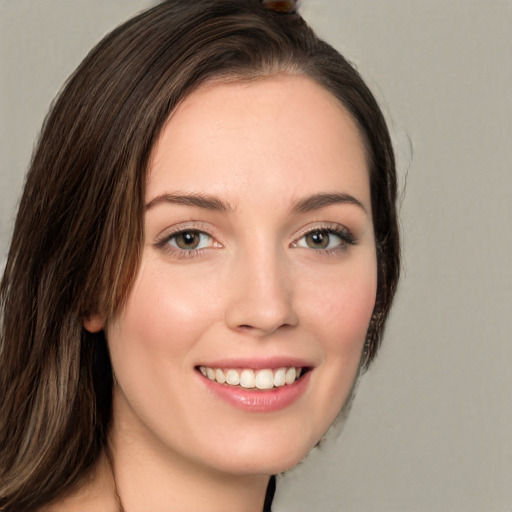 Joyful white young-adult female with long  brown hair and green eyes