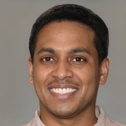 Joyful latino young-adult male with short  black hair and brown eyes