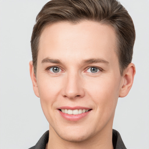 Joyful white young-adult male with short  brown hair and grey eyes